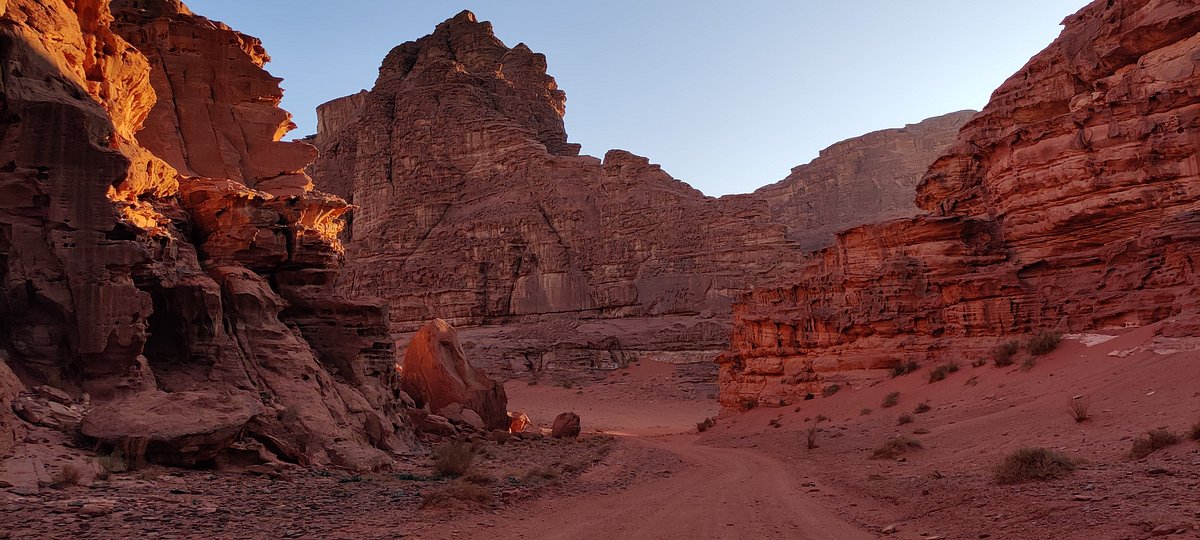 Massive sandstone mountains rising from the desert at Wadi Rum